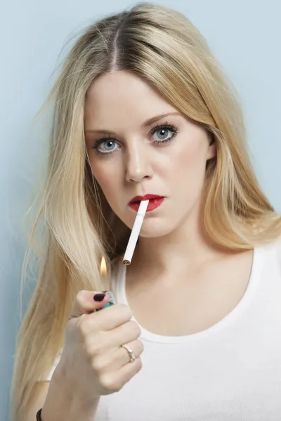 Young blond woman igniting cigarette — Stock Photo, Image