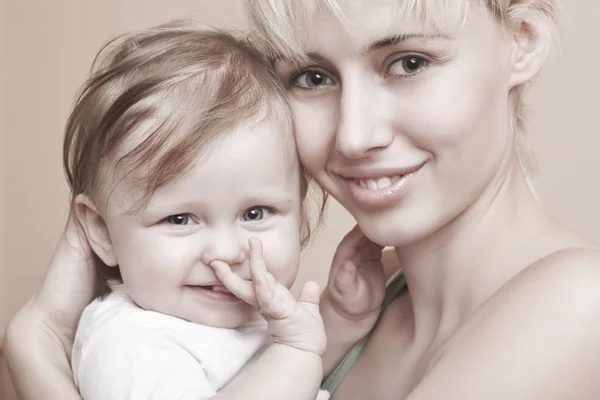 金发的母亲用一只手的婴儿抱在嘴里 — 图库照片
