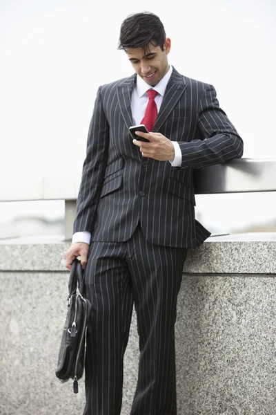 Uomo d'affari indiano sms attraverso il telefono cellulare — Foto Stock