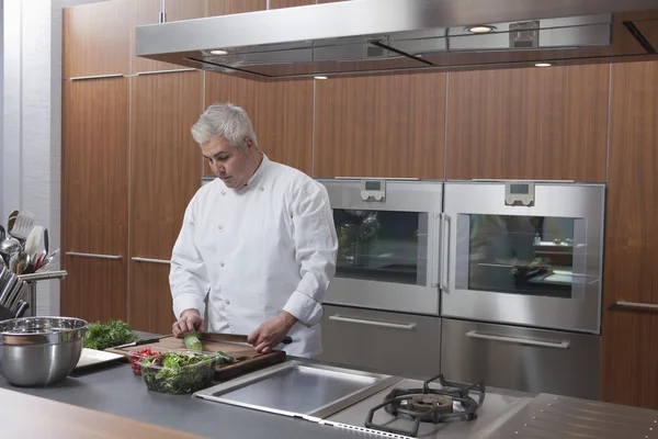 Mid- adult chef prepares salad — Stock Photo, Image