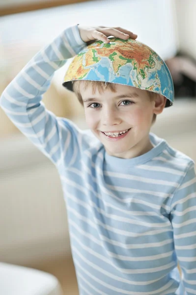 Kleiner Junge mit Globus auf dem Kopf — Stockfoto