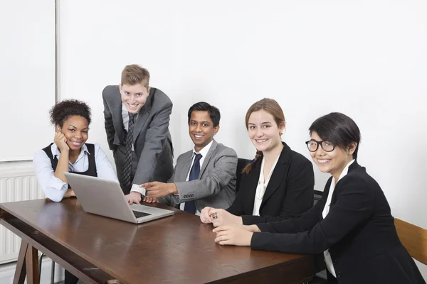 Multiethnic professionals using laptop — Stock Photo, Image