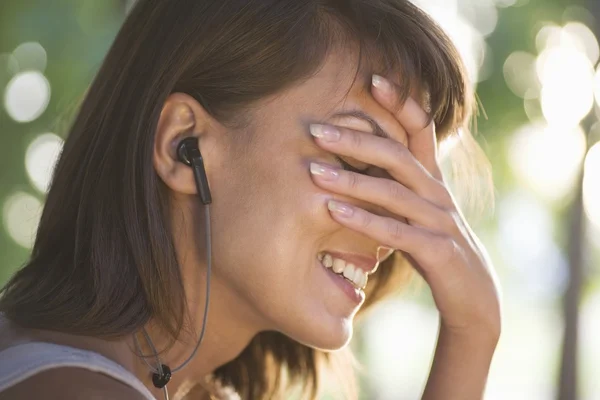 Wanita menutupi wajahnya tertawa dengan headphone — Stok Foto