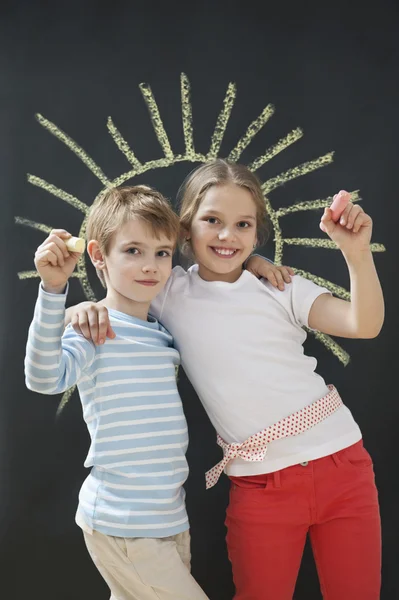 Siblings holding chalks — Stock Photo, Image