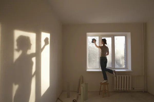 Mujer limpiando ventanas en apartamento nuevo — Foto de Stock