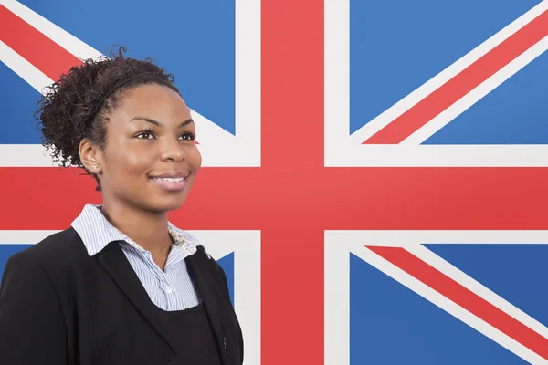 Affärskvinna leende över brittiska flaggan — Stockfoto