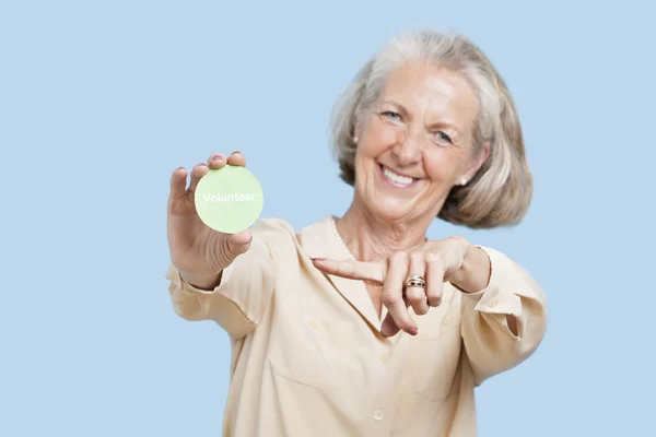 Senior woman holding volunteer badge — Stock Photo, Image