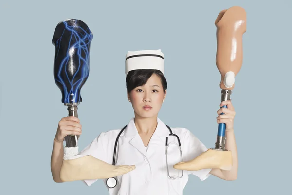 Médico segurando duas pernas artificiais — Fotografia de Stock
