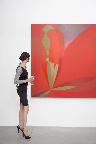 Woman looking at painting — Stock Photo, Image