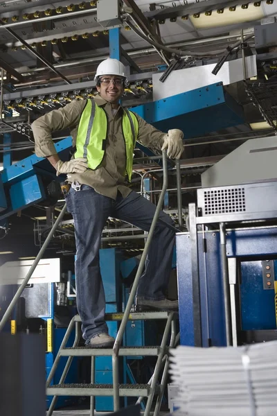 Man working in factory on steps — Stock Photo, Image