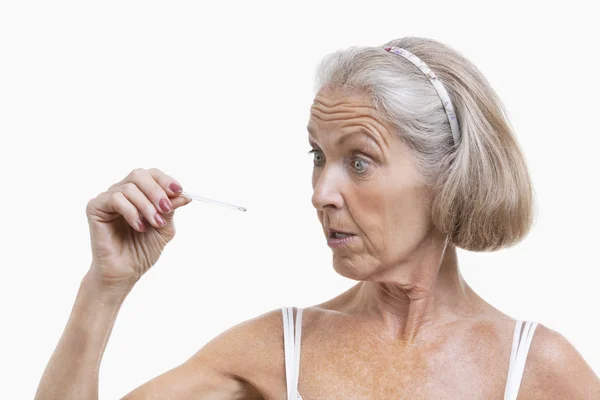 Seniorin überprüft Thermometer — Stockfoto