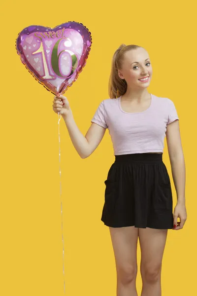 Mujer sosteniendo corazón en forma de globo de cumpleaños — Foto de Stock