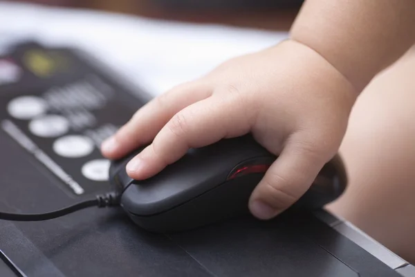 La main de bébé tient la souris d'ordinateur — Photo