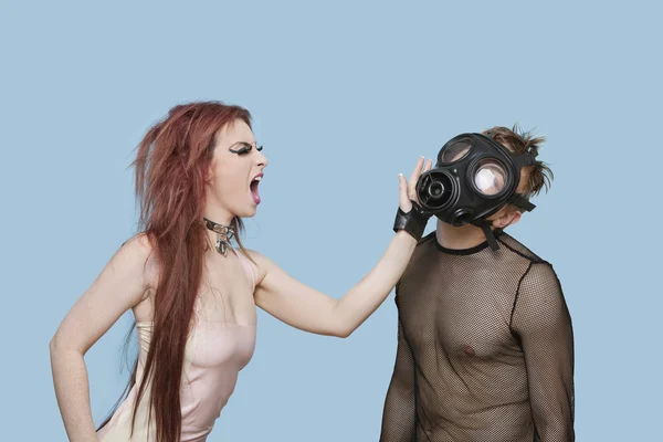 Frau schlägt Mann mit Gasmaske — Stockfoto