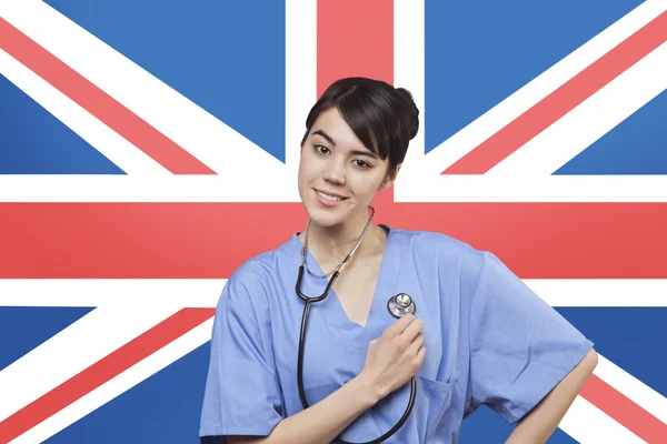 Female surgeon standing over British flag — Stock Photo, Image