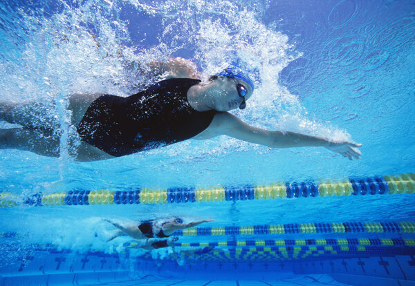 female swimmers racing in swimming pool 