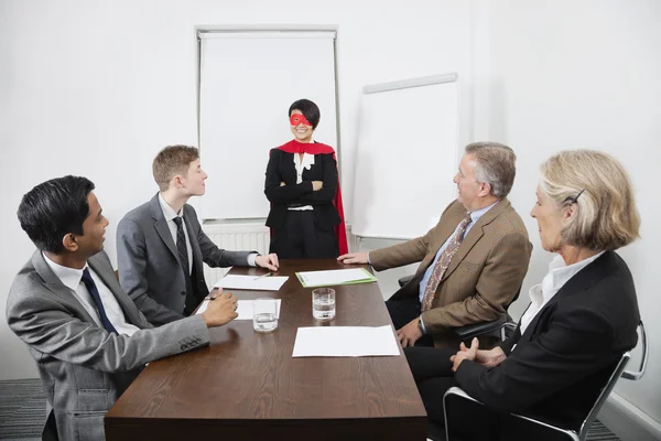 Business leader superhero in front of colleagues — Stock Photo, Image