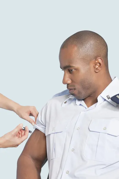 Military man getting an injection from nurse — Stock Photo, Image