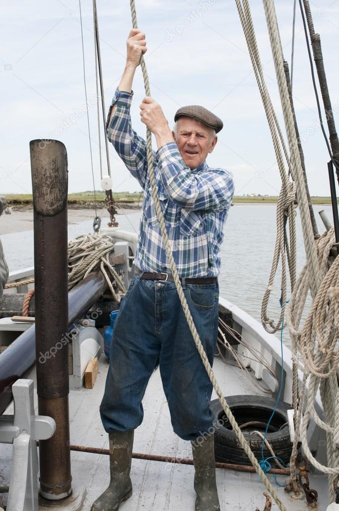 Elderly fisherman pulling rope 