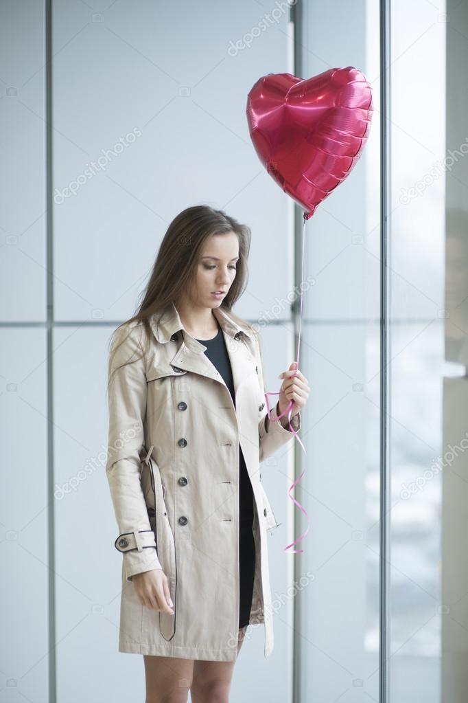 Sad woman holding heart shaped balloon