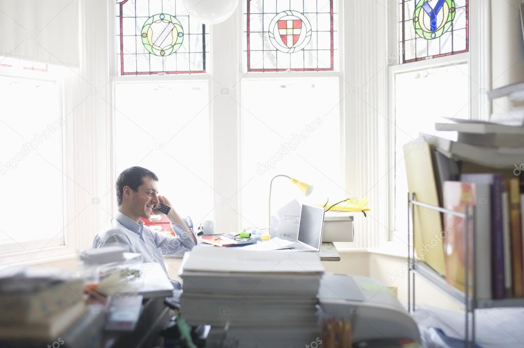 Businessman works from desk in bay window