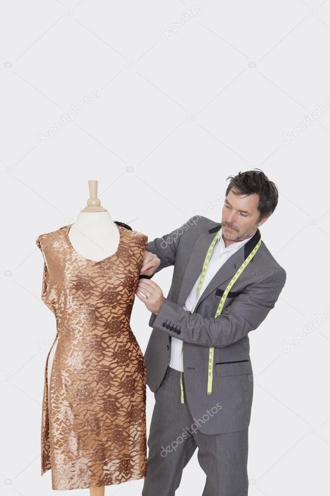 Designer adjusting cloth on tailor's dummy