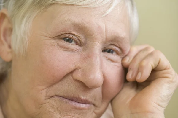 Elderly woman   leaning on hand — Stock Photo, Image