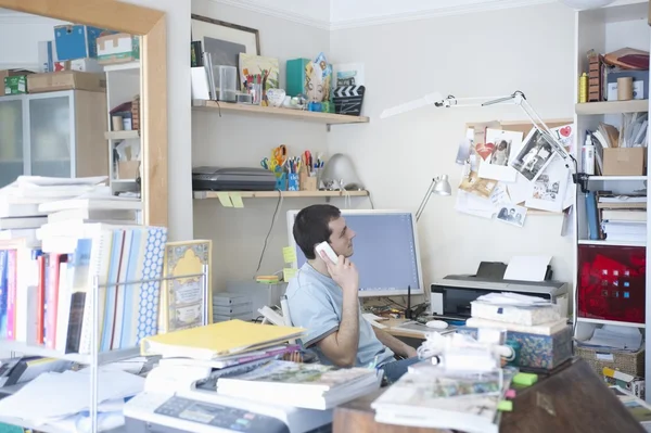 Creative professional sits on phone in corner of office — Stock Photo, Image