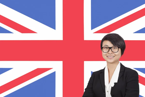 Businesswoman smiling over British flag — Stock Photo, Image