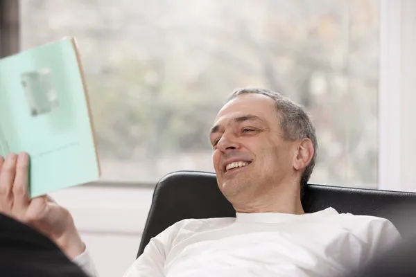 Mittlerer erwachsener Mann entspannt zu Hause beim Lesen eines Buches — Stockfoto
