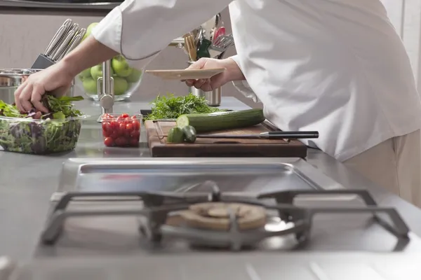 Chef-kok voorbereiding salade op keuken — Stockfoto