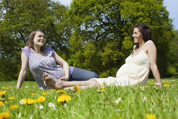 Femmes enceintes assises sur l'herbe — Photo