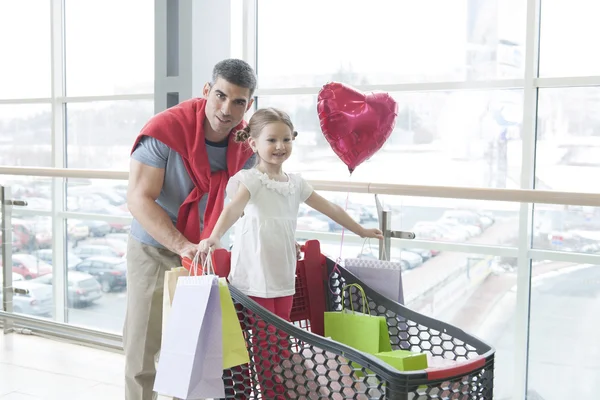 Pai empurrando filha no carrinho de compras — Fotografia de Stock