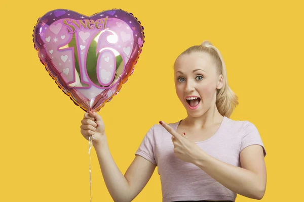 Donna che tiene palloncino di compleanno a forma di cuore — Foto Stock