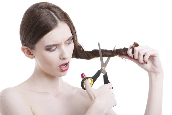 Woman with scissors cutting her hair — Stock Photo, Image