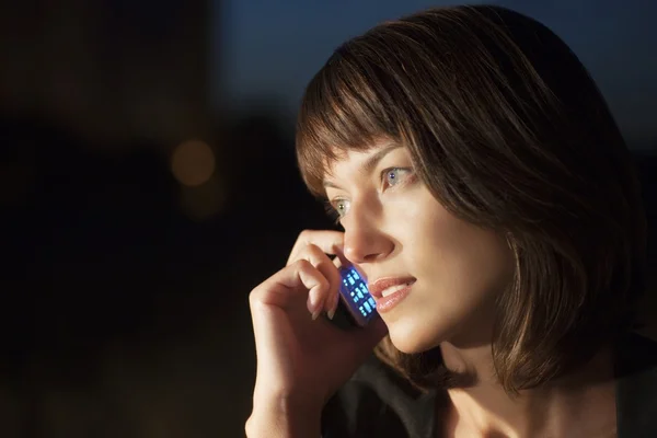 Woman talks on mobile phone at night — Stock Photo, Image