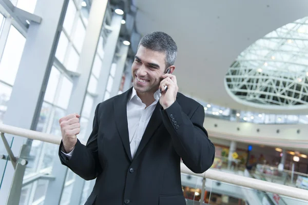 Businessman celebrates talking on mobile phone — Stock Photo, Image