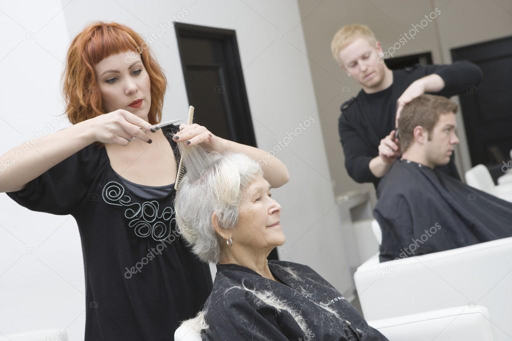 Stylist cuts elderly woman's hair