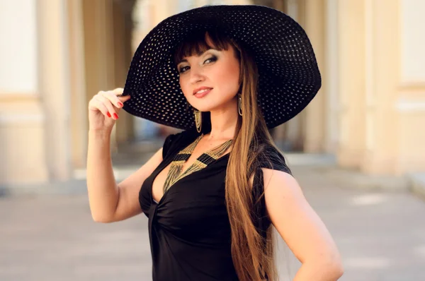 Attractive young lady in a black hat — Stock Photo, Image