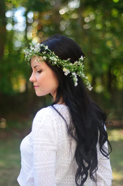 Jovem com cabelo preto longo e coroa de flores — Fotografia de Stock