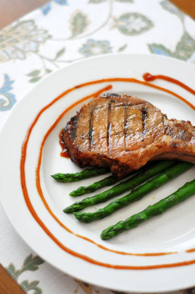 Grilled porkchop on the bone served with asparagus — Stock Photo, Image