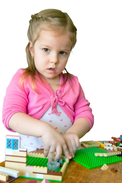 Małe dziecko wytrwale buduje dom. gra z designe — Zdjęcie stockowe