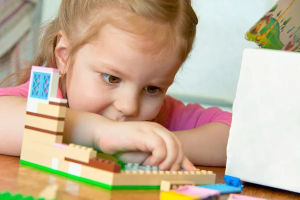Small child plays with the designer. Builds the house Stock Image
