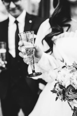 Gelin elinde bir bardak lezzetli şampanya tutuyor.