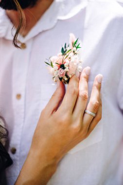 Güzel bir gelin damadın yaka çiçeğini düzeltir.