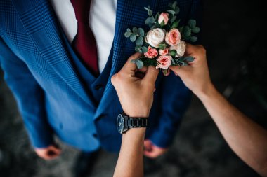 Güzel bir gelin damadın yaka çiçeğini düzeltir.