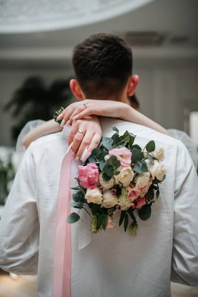 白いドレスを着た花嫁が花束を持って新郎を抱きかかえて — ストック写真