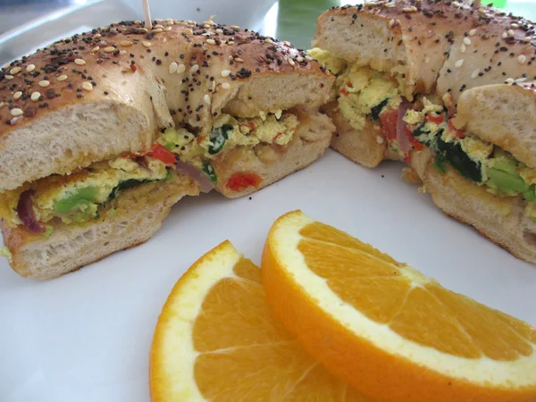 Veggie omelette sandwich with orange slices