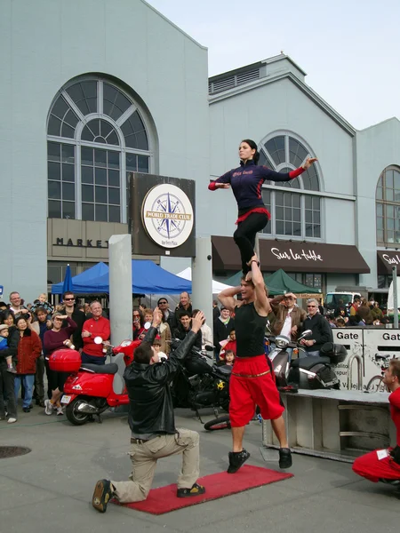 Man balances his sister on his shoulders tries to pass her to a — Stock Photo, Image