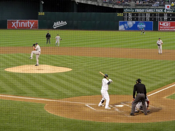 Pitcher winds up by raising leg to throw pitch to batter — Stock Photo, Image